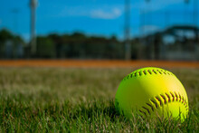 Close-up Of Softball In The Outfield Grass Of A Softball Or Baseball Field. Empty Field Used For Sports Teams.