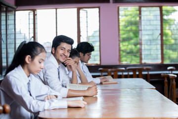 portrait of Indian school student  sitting in library looking at the camera