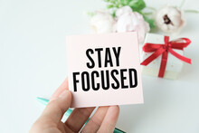 STAY FOCUSED Message On The Card Held By A Woman Hand