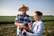 © Budimir Jevtic - Young farmer talking to insurance sales rep while walking in field.