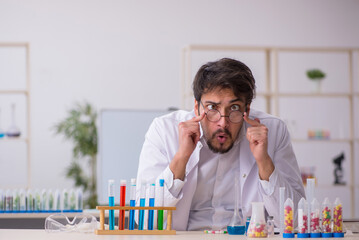 Young male chemist in drugs synthesis concept