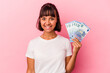© Asier - Young mixed race woman holding bills isolated on pink background happy, smiling and cheerful.