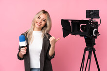Reporter Woman Holding A Microphone And Reporting News Over Isolated Pink Background Pointing To The Side To Present A Product