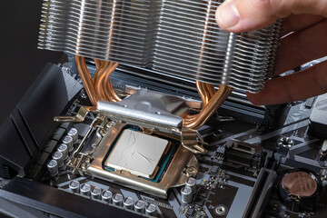 Wall Mural - A technician installs an aluminum air-cooled heatsink on a desktop PC CPU. Air Cooler CPU. PC assembly and modernization