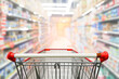 © nonnie192 - Supermarket aisle with empty red shopping cart.