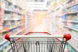 Fototapeta  - Supermarket aisle with empty red shopping cart.