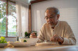 © Kawee - Unhappy Asian Senior older man sit alone, eat foods on table in house.