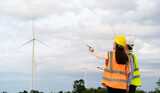 Fototapeta Storczyk - engineer team working with report in clipboard against wind turbine farm