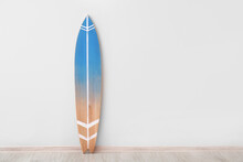 Blue Surfboard Near Light Wall