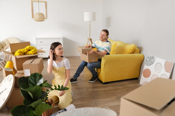 Sticker - Young couple with cardboard boxes in their new house on moving day