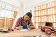 © godji10 - Portrait of females carpenter using mobile phone while checking list on the notebook