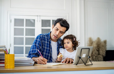 Young attractive father and little cute daughter watching the video tutorial on the tablet and teaching homwork at home with happiness.