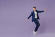 © ViDi Studio - Full size young successful employee business man lawyer 20s wear formal blue suit white t-shirt work in office stand on toes have fun spread hands isolated on pastel purple background studio portrait.