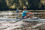 Sportsman single scull man rower rowing at competition boat regatta river