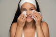 © vladimirfloyd - young happy woman with headband cleans her face with wet wipes