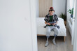 © Halfpoint - Portrait of disabled young man using tablet on bed indoors at home, leg prosthetic concept.
