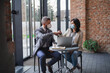 © Halfpoint - Portrait of businesspeople sitting at the table and working indoors, coronavirus concept.