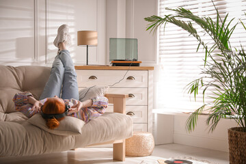 Poster - Young woman listening to music with turntable in living room