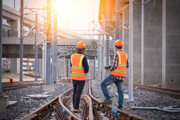 Engineer under inspection and checking construction process railway switch and checking work on railroad station .Engineer wearing safety uniform and safety helmet in work