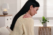 Woman suffering from shoulder pain at home