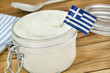 Greek yogurt and flag on wooden table