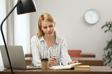 Poster - Young woman reading book at table in library