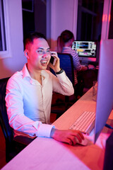 Wall Mural - happy smiling young software engineer talking on phone with coworker when discussing programming cod