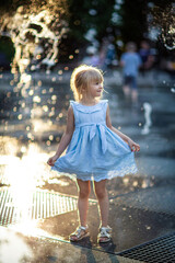 Wall Mural - happy little girl running under splashing water