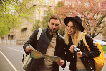 Canvas Print - Couple of tourists with map and camera on city street