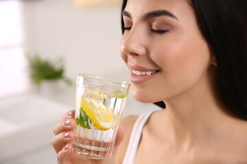 Poster - Young woman with glass of fresh lemonade at home, closeup