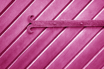 Wall Mural - Old metal door hinge on wooden door in pink tone.