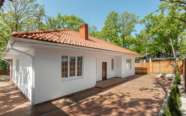 Backyard of modern white country house with brown roof. . High quality photo