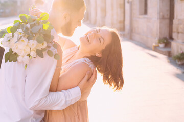 Gorgeous wedding couple embrace affectionately while posing for the camera on the street. The concept of a new family, love and relationships.