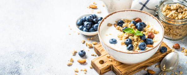 Wall Mural - Yogurt with granola and fresh berries at stone table. Healthy food, snack or breakfast. Long banner format.