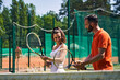 © Viacheslav Yakobchuk - Instructor showing a proper tennis grip technique to his client