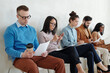 © pressmaster - Several young applicants sitting along wall while waiting for their turn for interview