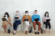 Young multiracial applicants in protective masks looking through their resume