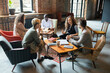© pressmaster - Young businesswoman explaining her colleagues one of working points at meeting