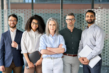 Happy Diverse Business People Team Standing Together In Office, Group Portrait. Smiling Multiethnic International Young Professional Employees Company Staff With Older Executive Leader Look At Camera.