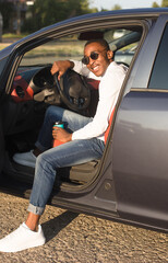 Wall Mural - happy african american driving a car with coffee, in the summer