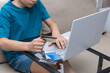 © Anna - Boy with credit card in his hand in front of laptop making online payment.  Online shopping from home.