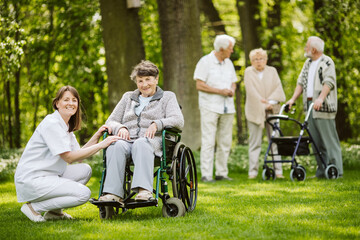 Canvas Print - Happy nurse and elder woman on the wheelchair