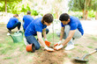 © AntonioDiaz - Diverse volunteers digging a hole to plant a tree
