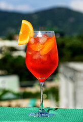 Wall Mural - Glass of cold refreshing cocktail with ice and fresh orange slice