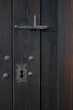 Fragment starych, drewnianych drzwi z metalowym zamkiem i zamknięciem