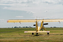 Yellow Vintage Plane On The Airfield Waiting To Go Into The Air View From The Back. Conventionally Laid Out Single-engine, High-wing Light Aircraft With Seating For Two
