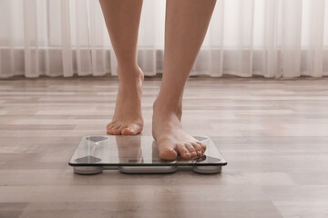 Canvas Print - Woman stepping on floor scales indoors, closeup. Weight control