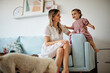 © chika_milan - Young beautiful mother playing with her beloved baby girl at home.