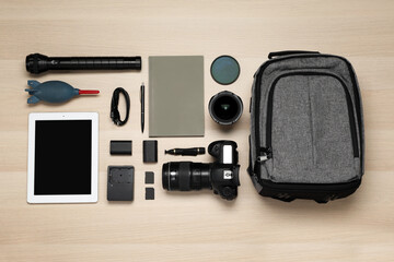 Wall Mural - flat lay composition with professional photography equipment and backpack on wooden table