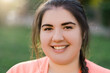 © golubovy - Smiling woman. Overweight people. Body acceptance. Positive thinking. Portrait of joyful happy young obese plus size girl outdoors in defocused green park landscape.
